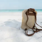 Mochila de rafia crema para mujer con bolsillo delantero y detalles marrones