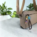 Bolso bandolera beige de nylon acolchado para mujer con bolsillos