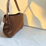 Bolso marrón de antelina con trenzado decorativo y herrajes metálicos