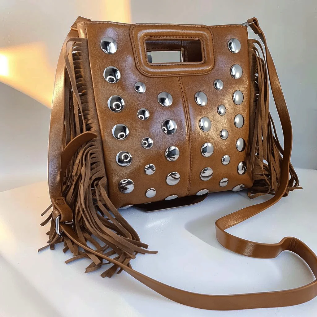 Bolso camel de piel vegana con flecos y tachuelas plateadas