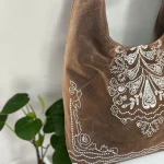 Bolso hobo mujer topo de antelina con bordados blancos