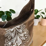 Bolso hobo mujer topo de antelina con bordados blancos