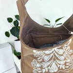Bolso hobo mujer topo de antelina con bordados blancos