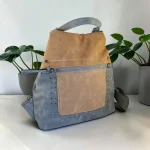 Mochila antirrobo de mujer de antelina azul y beige con tachuelas metálicas y bolsillo delantero