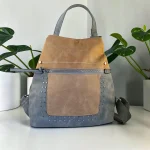 Mochila antirrobo de mujer de antelina azul y beige con tachuelas metálicas y bolsillo delantero